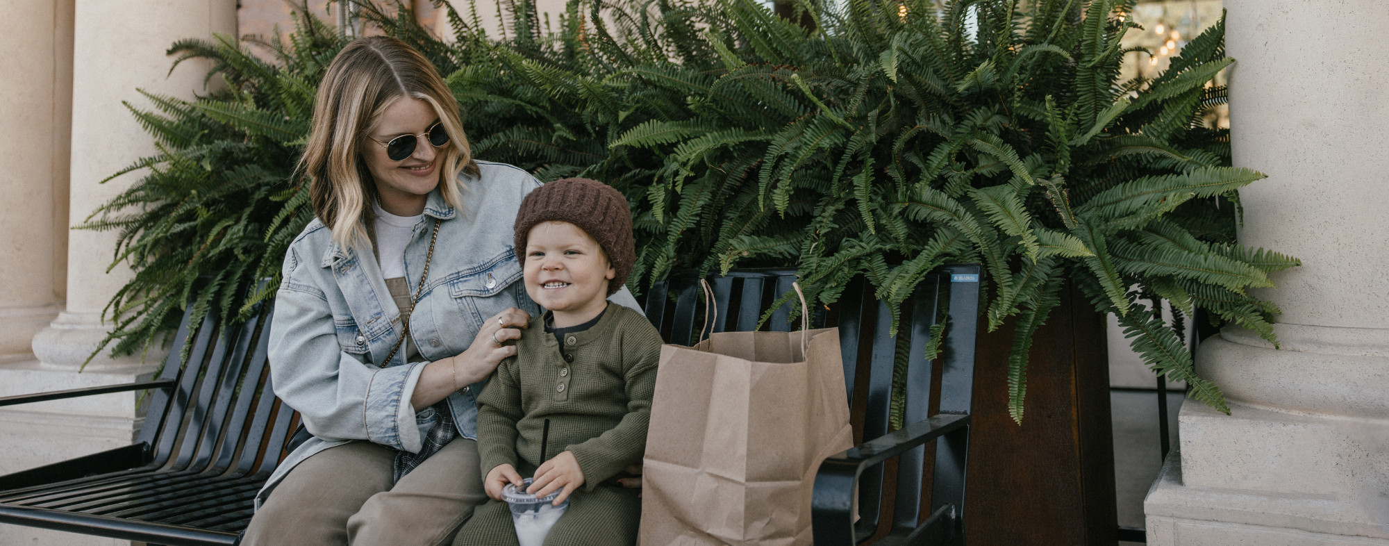 mother and son on bench with shopping bags