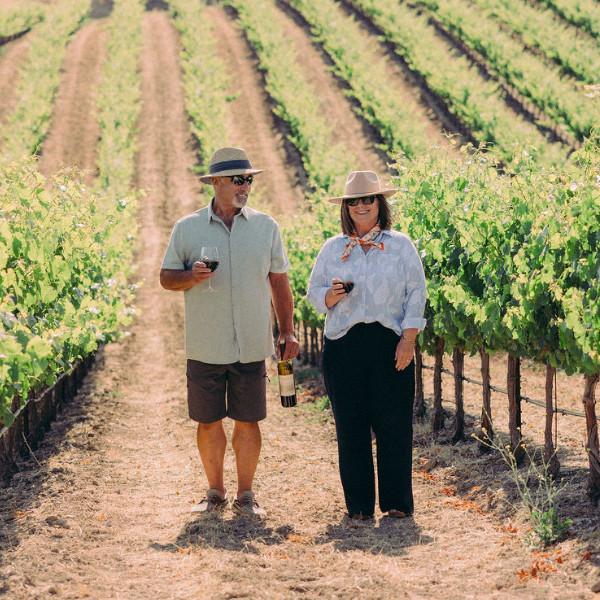 Couple walking through Kula Vineyards wine grapes in Atascadero