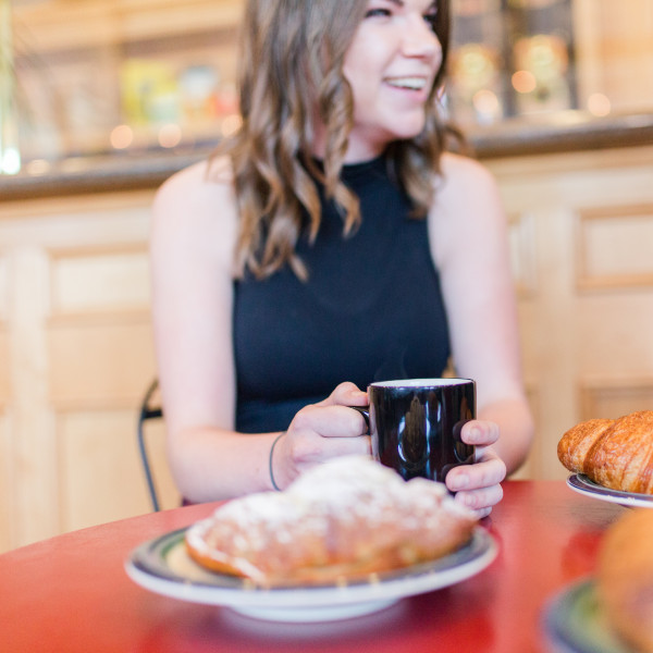 A woman having coffee and a croissant in Atascadero
